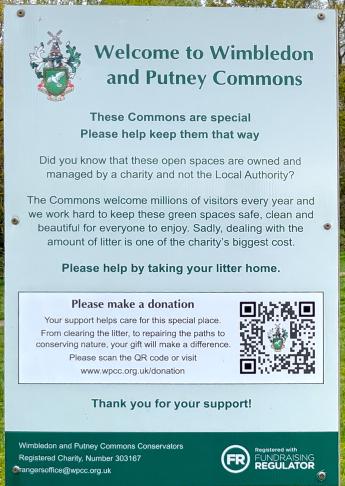 A metal sign welcoming readers to the Wimbledon and Putney Commons. It goes on to explain how the commons are managed, reminding people to take their litter home and ends with a QR Code which can be scanned to make a donation to the Wimbledon and Putney Commons Conservators to help with the upkeep of the commons.